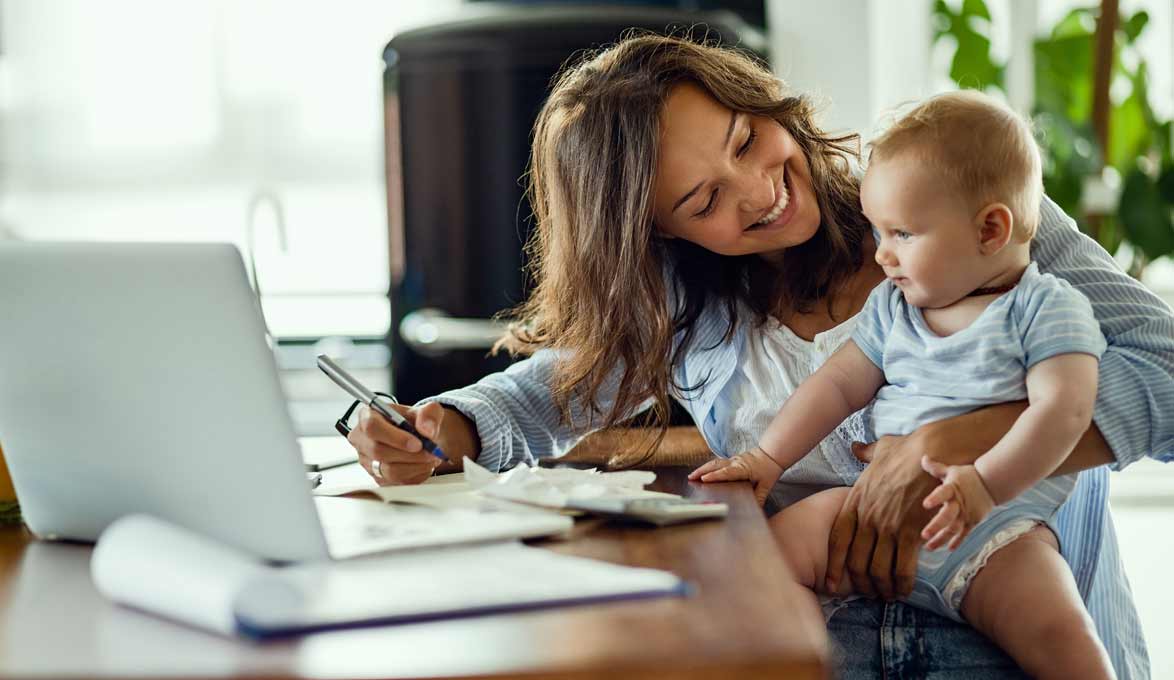 Mom holding baby while reviewing fiances.